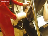 Babe in red shiny latex pegging a bound stud with a huge strapon